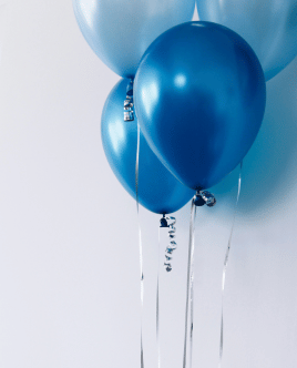 Blaue Luftballons als Symbol für einen fröhlichen Kindergeburtstag und unvergessliche Feiermomente